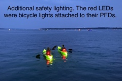 Lighted kayaks from behind.
